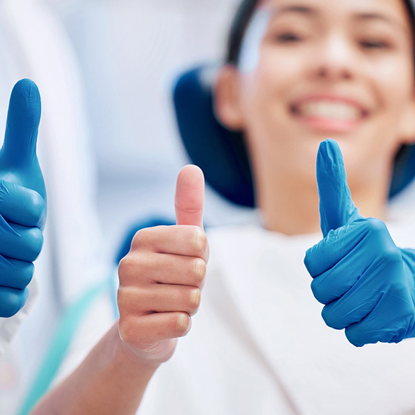 lady in dental chair with thumbs up